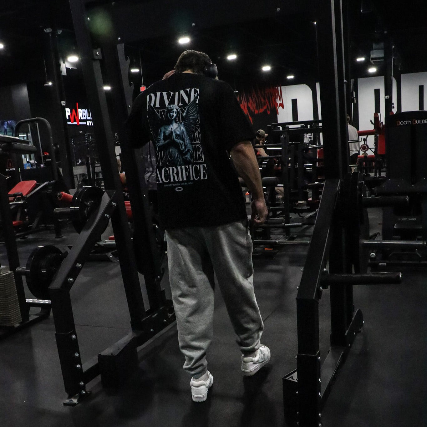 Person wearing a black t-shirt with graphic design in a gym setting